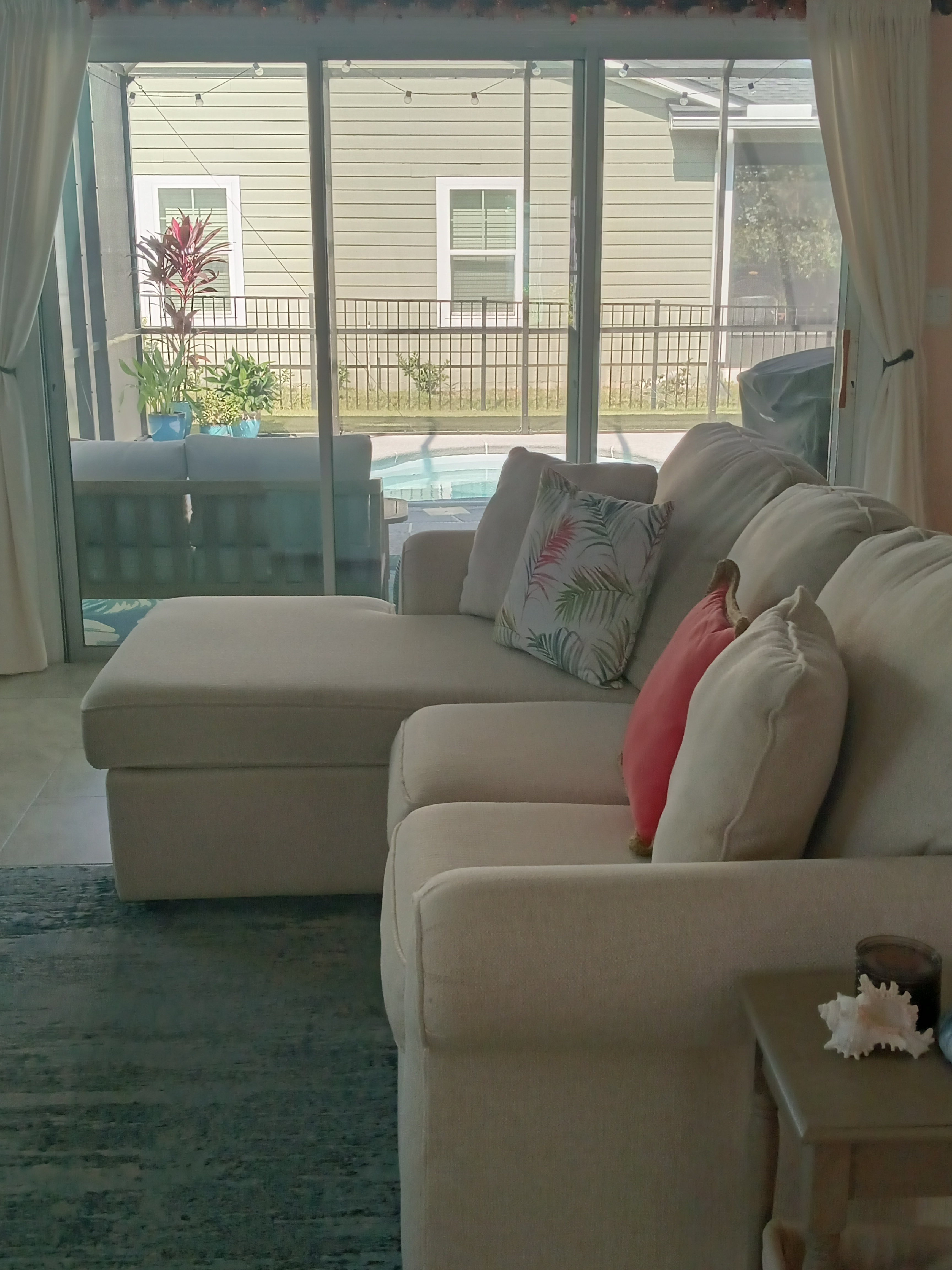 Living room sectional with pool view through sliding door