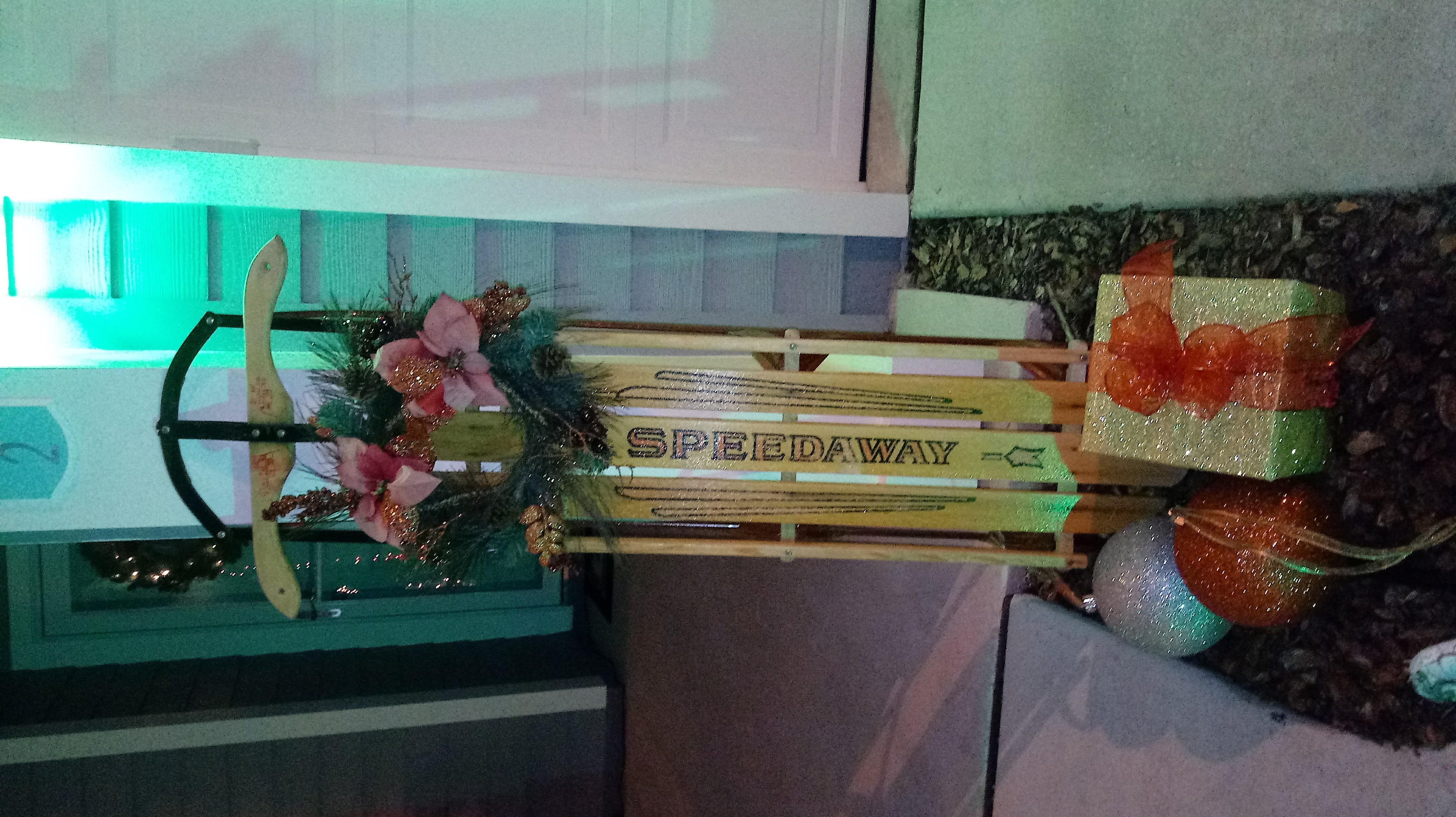 Vintage Christmas sled decoration with poinsettia wreath and gifts